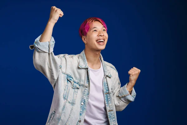 Asiatischer Junge Mit Rosa Haaren Schreit Während Siegergeste Auf Blauem — Stockfoto