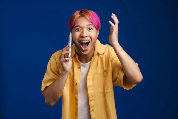 Azji Podekscytowany Chłopiec Różowymi Włosami Rozmowy Telefon Komórkowy Odizolowany Niebieskim — Zdjęcie stockowe