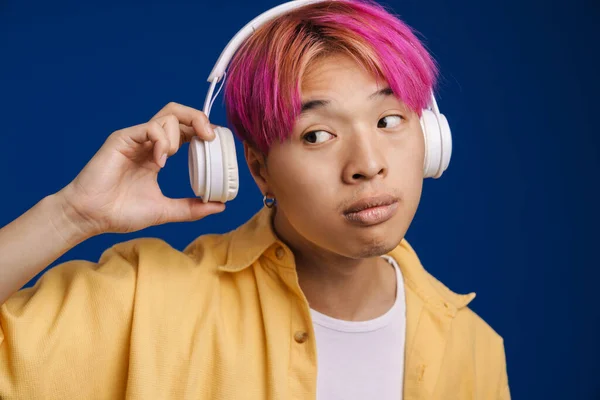 Asiatischer Junge Mit Rosa Haaren Hört Musik Mit Kopfhörern Isoliert — Stockfoto