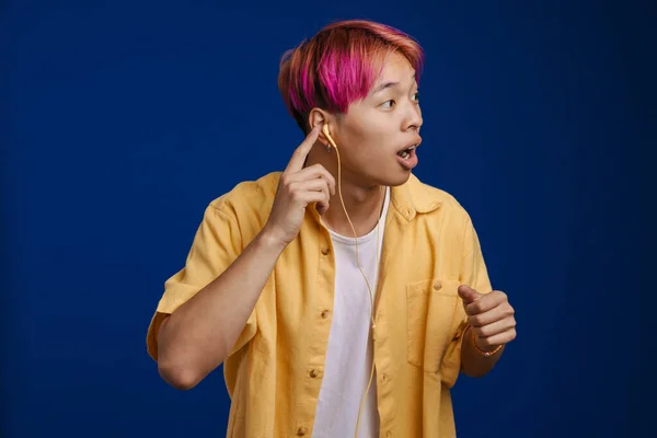 Asiatischer Junge Mit Rosa Haaren Hört Musik Und Schaut Isoliert — Stockfoto