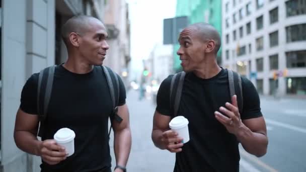 两个快乐的秃头非洲兄弟在街上边喝咖啡边聊天边走 — 图库视频影像