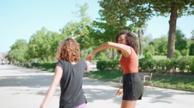 Neşeli Afrikalı anne ve kız yazın parkta dans ediyor.