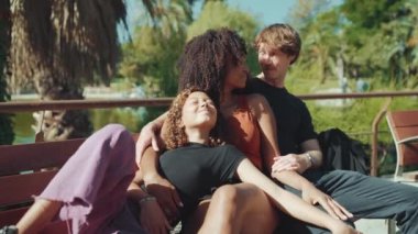 Yazın parkta bankta otururken neşeli çoklu etnik aile sohbeti.