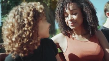 Yazın parkta bankta konuşan Afrikalı anne ve kız memnun.