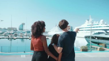 Çok ırklı bir ailenin yaz mevsiminde toprak setinde konuşmasının ve ayakta durmasının arka planda kalan kısmı.