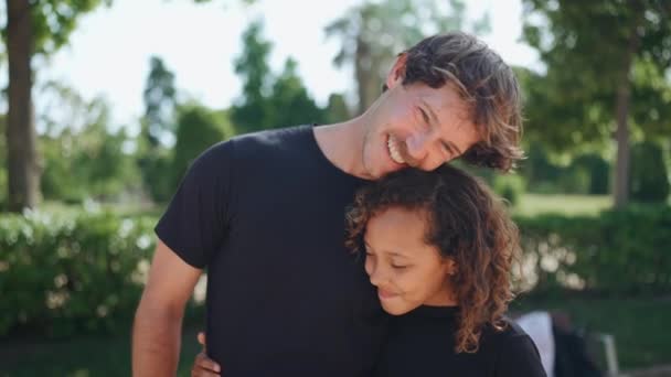 Uśmiechnięty Ojciec Przytulający Swoją Wielonarodową Córkę Patrzący Nią Latem Parku — Wideo stockowe