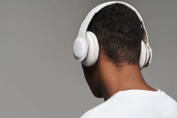 Joven Hombre Negro Escuchando Música Con Auriculares Inalámbricos Aislados Sobre —  Fotos de Stock