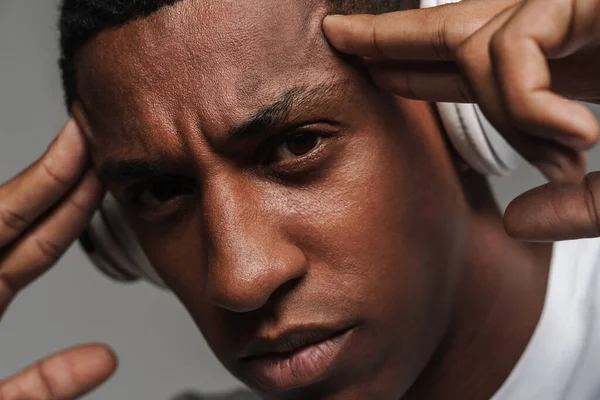 Junger Schwarzer Mann Mit Drahtlosen Kopfhörern Reibt Sich Isoliert Grauer — Stockfoto