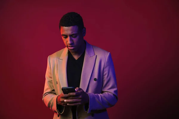 Young Black Man Dressed Jacket Using Mobile Phone Isolated Red — Stockfoto