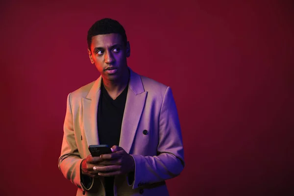 Young Black Man Dressed Jacket Using Mobile Phone Isolated Red — Stockfoto