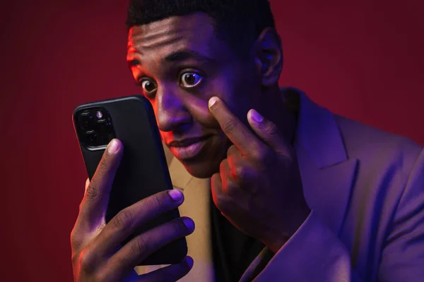 Junger Schwarzer Mann Jacke Blickt Auf Handy Über Roter Wand — Stockfoto