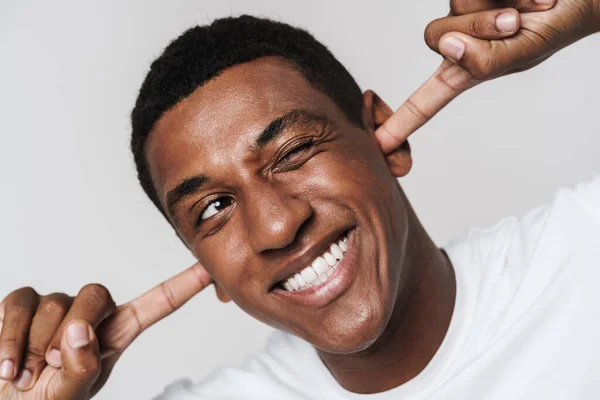 Joven Hombre Negro Sonriendo Guiñando Ojo Mientras Tapaba Las Orejas — Foto de Stock