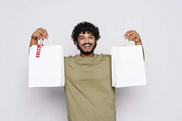 Young Middle Eastern Man Laughing While Posing Shopping Bags Isolated — Stock fotografie