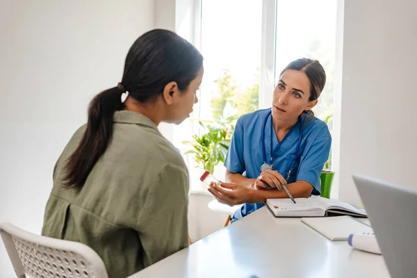 Doctora Blanca Hablando Con Paciente Mientras Trabaja Consultorio Interiores — Foto de Stock