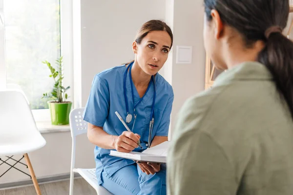 Doctora Blanca Hablando Con Paciente Mientras Trabaja Consultorio Interiores — Foto de Stock