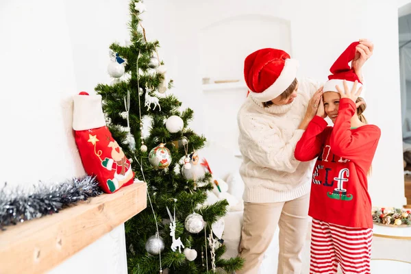 Bílá Dívka Její Babička Nosí Santa Klobouky Vánočního Stromečku Doma — Stock fotografie