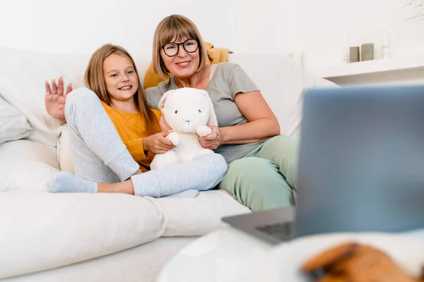 在家里用笔记本电脑玩玩具的白人女孩和她的祖母 — 图库照片