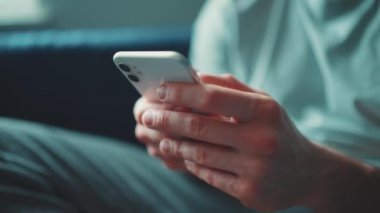 Male hands texting on smartphone indoors at home