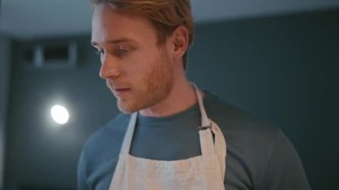 Pretty blond athletic man cooking in the kitchen at home