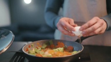 Erkek eller evdeki tavaya yumurta döker.