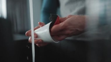 Erkek eli evde bulaşıkları yıkar.