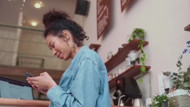 Χαρούμενη Γυναίκα Afro Πληκτρολόγηση Μαλλιών Στο Τηλέφωνο Και Εργάζονται Φορητό — Αρχείο Βίντεο