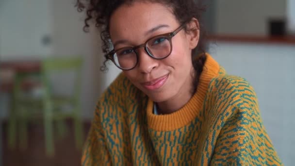 Wanita Ceria Mengenakan Sweater Kuning Dan Kacamata Melihat Kamera Kafe — Stok Video