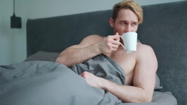 正金发碧眼的运动员 全身赤裸 躺在床上喝咖啡 — 图库视频影像