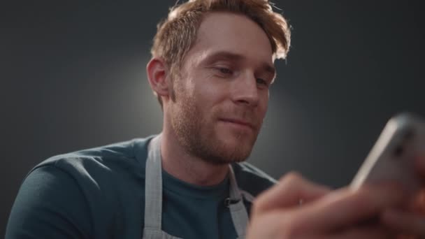 Happy Athletic Blond Man Wearing Apron Texting Mobile Kitchen Home — Wideo stockowe