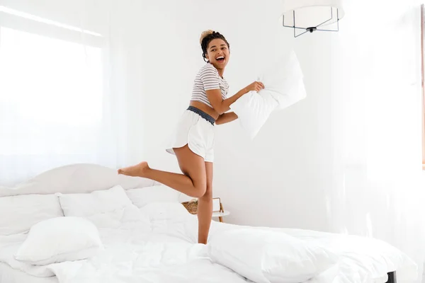 Young Black Woman Laughing While Making Fun Pillow Bed Home — Stock fotografie