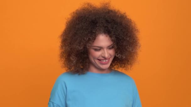 Confused Curly Haired Blonde Woman Wearing Blue Shirt Looking Orange — Stockvideo
