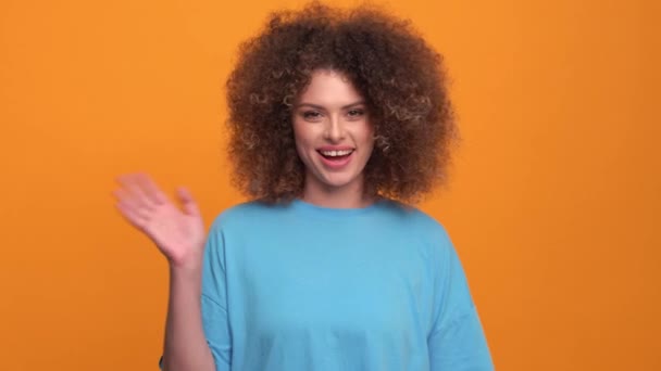 Smiling Curly Haired Blonde Woman Wearing Blue Shirt Greeting Camera — Stockvideo