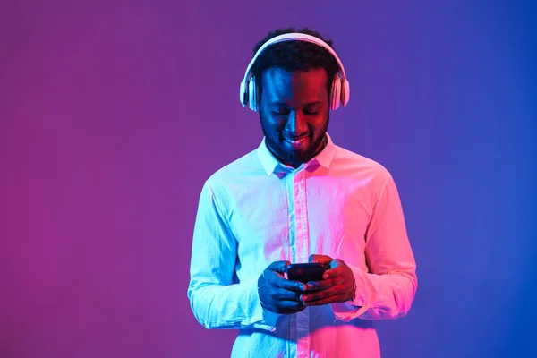 Jonge Zwarte Man Luisteren Muziek Met Koptelefoon Mobiele Telefoon Geïsoleerd — Stockfoto