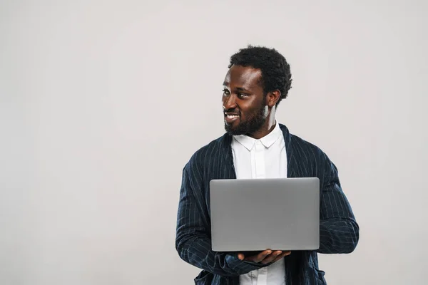 Young Black Man Wearing Jacket Smiling While Typing Laptop Isolated — Fotografia de Stock