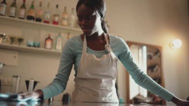 Kafe 'de beyaz önlük giyen kendinden emin Afrikalı kadın barmen.