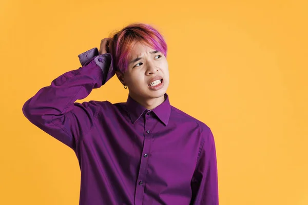 Asian Boy Pink Hair Frowning Looking Aside Isolated Yellow Wall — Stock fotografie