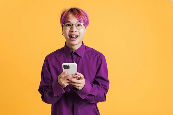 Asian Boy Eyeglasses Laughing Using Cellphone Isolated Yellow Wall — 스톡 사진