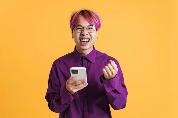 Asyalı Çocuk Sarı Duvardan Izole Edilmiş Cep Telefonu Kullanarak Gülüyor — Stok fotoğraf