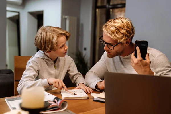 Ginger Son Doing Homework His Father While Sitting Desk Home — Foto Stock