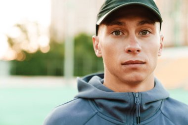 Genç beyaz koşucu dışarıda stadyumda çalışırken egzersiz yapıyor.