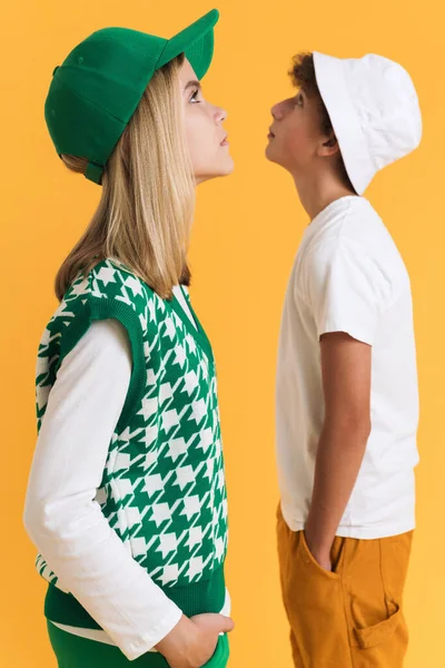 White Girl Boy Hats Looking Different Directions Isolated Yellow Background — Stockfoto