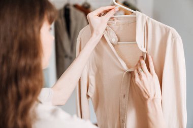 Önlüklü beyaz bir kadın evde ev işi yapıyor.