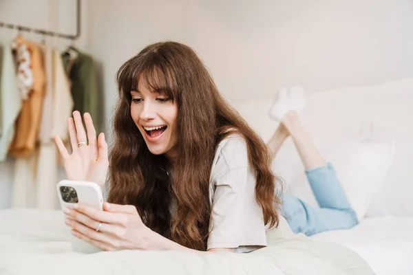 White Woman Gesturing Using Mobile Phone While Lying Bed Home — Stock Fotó