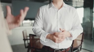 Hands of colleagues wearing formal cloth and gesturing in the office