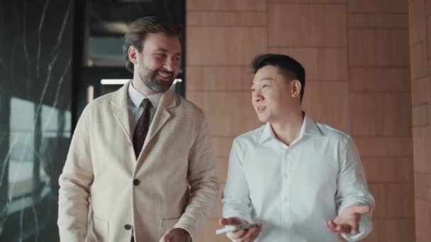 Smiling Multinational Colleagues Talking Work While Walking Office — Stockvideo