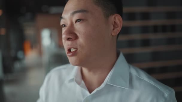 Meditative Asian Brunet Businessman Talking Something While Standing Office — Vídeo de Stock