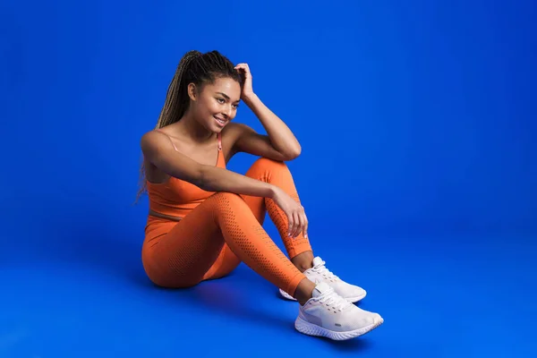 Black Young Sportswoman Smiling While Sitting Floor Isolated Blue Background — Stock fotografie