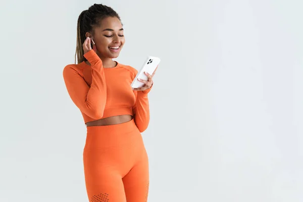 Black Young Sportswoman Using Smartphone Earphones Isolated White Background — Stockfoto