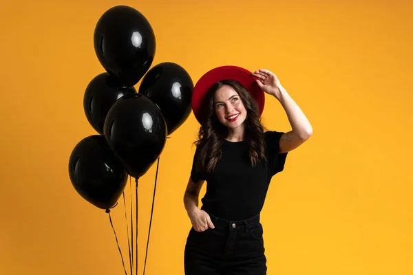 White Woman Red Hat Smiling While Posing Black Balloons Isolated — стоковое фото