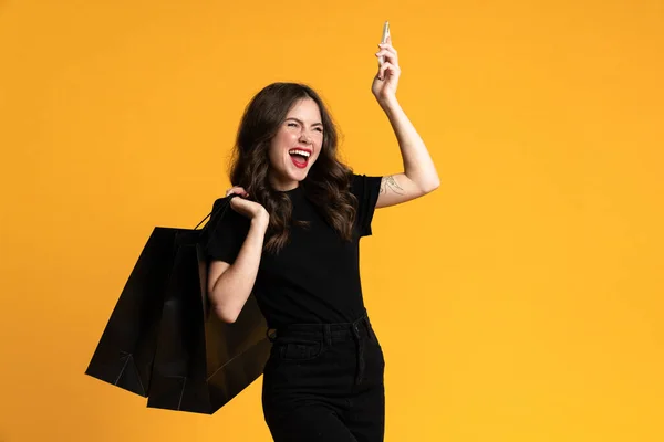 White Excited Woman Posing Shopping Bags Cellphone Isolated Yellow Background — Photo
